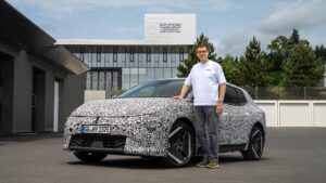 Stephan Hoferer steht neben dem getarnten Kia EV4 vor dem Hyundai Motor Group Entwicklungszentrum.