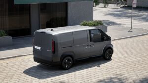 Heck- und Seitenansicht des Kia PV5 Cargo, geparkt auf einer städtischen Straße.