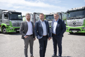 Drei Vertreter der Zellinger GmbH stehen vor den neuen eActros Elektro-Lkw.