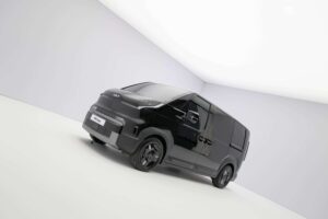 Kia PV5 Cargo in Schwarz, schräg von vorn im Studio aufgenommen.