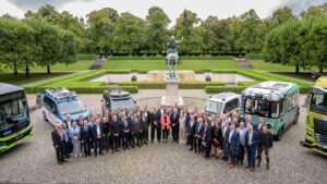 Gruppenfoto von Politik, Wissenschaft und Industrievertretern vor autonomen Fahrzeugen im Freien.