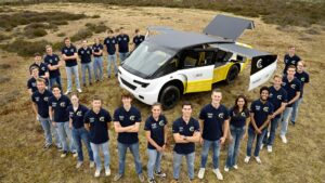 Studierendenteam der Technischen Universität Eindhoven präsentiert den solarbetriebenen Krankenwagen Stella Juva im Freien.