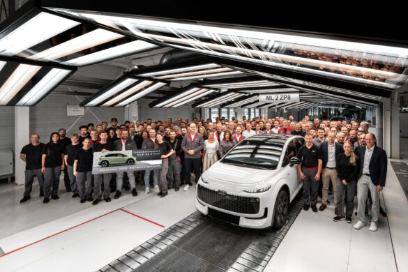 Audi A2 e-tron in der Produktion in Ingolstadt, umgeben von zahlreichen Mitarbeiterinnen und Mitarbeitern des Audi-Werks.