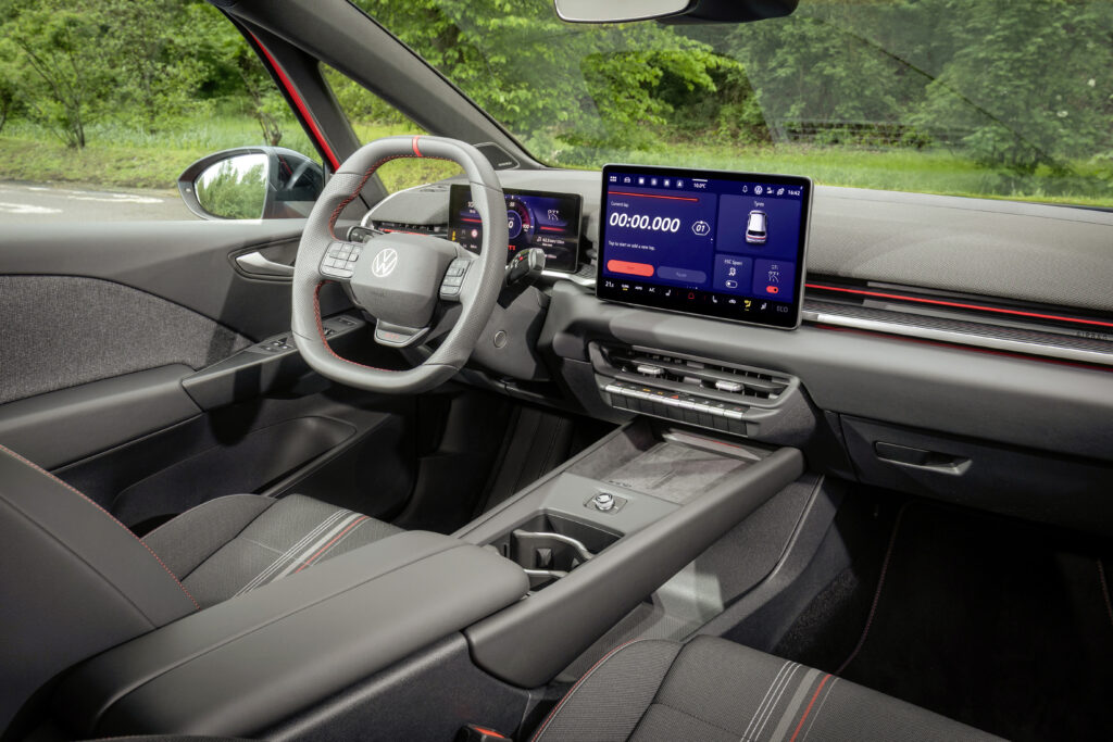 Innenraum des Volkswagen ID.3 GTI mit Sportlenkrad, digitalen Displays und roten GTI-Akzenten.