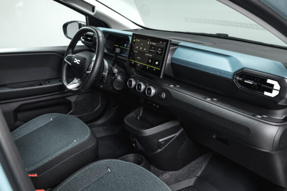 Innenraum des neuen Dacia Spring mit digitalem Cockpit, großem Multimedia-Touchscreen und modern gestaltetem Armaturenbrett.